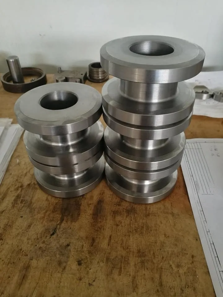 171823943_119836130190740_6914261777371387963_n-transformed Precizno izrađeni metalni dijelovi cilindričnog oblika složeni na radnom stolu u radionici za CNC obradu metala.